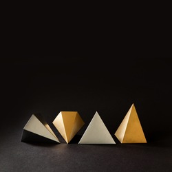 Minimal geometry still life composition. Platonic solids figures geometry. Abstract gold and silver color geometrical figures. Three-dimensional pyramid objects on black background.