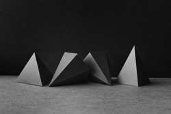 Platonic solids figures geometry. Abstract geometrical figures still life composition. Three-dimensional prism pyramid objects on black gray background