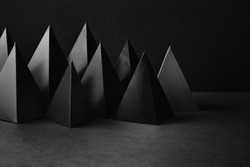 Prism pyramid objects on black gray background. Abstract geometrical figures still life composition