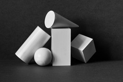 Platonic solids figures geometry. Abstract geometrical objects still life composition. Three-dimensional rectangular prism, cylinder pyramid cube, sphere on black gray background.