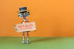 Sorry, we are closed. Crisis bankruptcy or service not available concept. Closed for maintenance or vacation. Toy character holds poster with handwritten apologizing message. copy space.