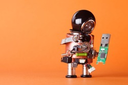 Robot with usb flash storage stick. Data storing and robotic technology concept, fun toy character black helmet head. Copy space, orange background, macro view soft focus.