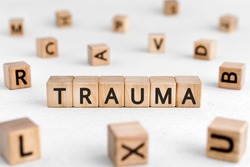 Trauma - words from wooden blocks with letters, physical or mental injury trauma concept, white background