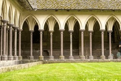 Columns of the gallery of the Abbey of Mont-Saint-Michel with grass lawn.