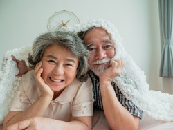 Good health mature couple smiling embracing health care lying In the bedroom, People lifestyle concept.