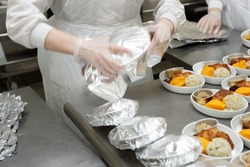 Chef is wrapping airline food in foil, professional kitchen