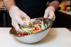 Chef is cooking a vegetarian salad at professional kitchen