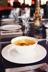 Bowl of pumpkin soup on restaurant table