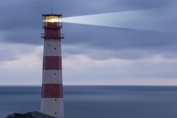 Lighthouse searchlight beam through marine air