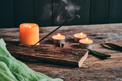 Smoke from incense stick and relaxing candles on rustic wood