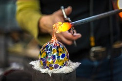 A Glass Blower Shaping Molten Glass into a Piece of Art