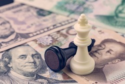 US and China finance trade war concept, black loser and white winner chess king on US dollar and china yuan banknotes, world major market countries.