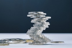 Unstable closed to collapse stack of coins tower , uncertainty of business, risk of financial or investment, no stability, problem or crisis concept.