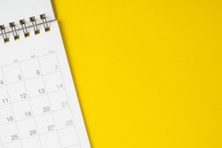 White clean calendar on solid yellow background with copy space, business meeting schedule, travel planning or project milestone and reminder concept.