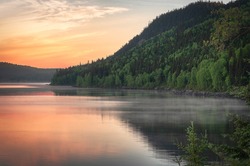 Beautiful Morning Sunrise on a Steamy Lake Surrounded by Mountains With Trees in Quebec Canada