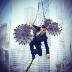 Businessman hindered by balls balanced on rope