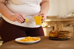 sugar addiction, unhealthy lifestyle, cholesterol, weight gain, dietary, healthcare and medical concept. cropped portrait of overweight woman eating sugary foods and drinking soda