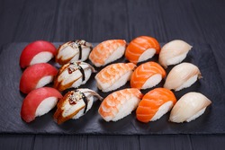 Traditional Japanese nigiri sushi set on black stone slate. Delicious seafood, sushi restaurant concept