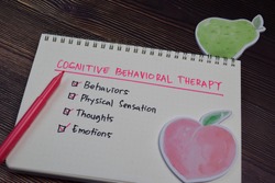 Cognitive Behavioral Therapy write on a book with keywords isolated wooden table.