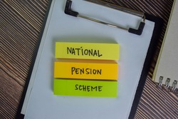 National Pension Scheme write on sticky notes isolated on Wooden Table. Selective focus on National Pension Shceme text