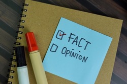 Fact or Opinion write on sticky notes isolated on Wooden Table.