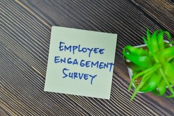 Employee Engagement Survey write on sticky notes isolated on Wooden Table. Selective focus on employee engagement text
