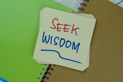 Concept of Seek Wisdom write on sticky notes isolated on Wooden Table.