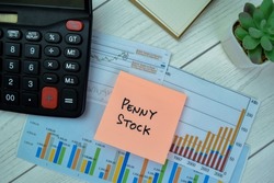 Concept of Penny Stock write on sticky notes isolated on Wooden Table.