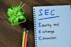 Concept of SEC - Security and Exchange Commision write on book isolated on Wooden Table.