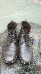 wet leather boots on the river stone