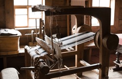 The ancient weaving loom in an interior of a wooden log hut