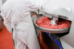 Process for the production of products of animal origin. Raw meat minced in an industrial process factory stored in a stainless steel crate at a processing.