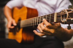 closeup hand musician playing acoustic guitar.concept for live music background,Music festival.Instrument on stage