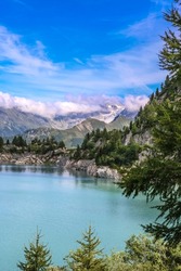 Scenic view in the Alps. Dam in the Alps, 1930 meters above sea level. Wonderful summer landscape. Vertical photo.