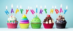 Colorful cupcakes with candles spelling Happy Birthday