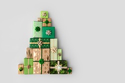Christmas gift boxes laid out in the shape of a Christmas tree, overhead view