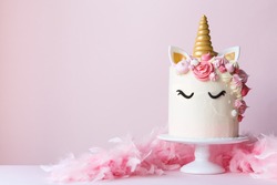 Unicorn cake with pink frosting and copy space to side