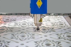 CNC cutting machine cutting pattern of flower on plastic sheet. Industrial manufacturing.