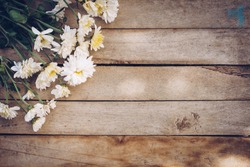Flowers on old grunge wooden table texture and background with copy space.