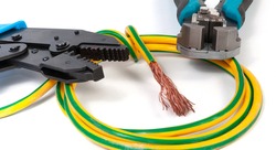 Electrician's tools. Stripper for stripping insulation on a wires and crimper for crimping lugs with grounding cable on a white background, close-up