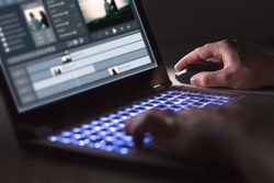 Video editing with laptop. Professional editor adding special effects or color grading footage for commercial film or movie. Man using software in computer.