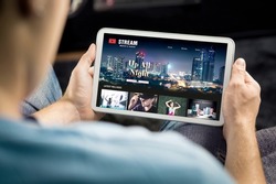 Movie and series stream VOD service in tablet. Watching on demand tv show or film online. Man choosing video entertainment from subscription media catalogue. Streaming website library mockup.