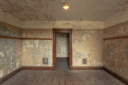 Empty old room in an abandoned building with peeling paint, wood trim and floors