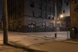 Beautiful street scene with vintage red brick factory buildings at night in a depressed urban blue collar industrial area with broken windows in St. Louis Missouri