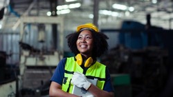 African-American woman machine operator technician in the manufacturing industry happy smile in the factory