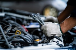 Close-up of a car mechanic repairing a car in a garage. car safety check The engine in the garage. Repair service concept.