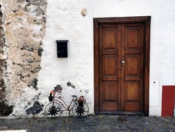 Big brown door with a decorative small bike in the city of Santa Cruz, La Palma, Spain