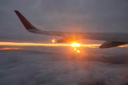 The wing of the plane at sunset. Plane on sunset. Wing aircraft at cloud sunset view from plane