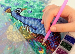 Diamond mosaic painting fragment of making close-up top view, handmade hobby.