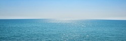 The surface of the sea of ​​the natural blue ocean, with the sunlight from the horizon reflecting on the waves and sparking into a panoramic view.
